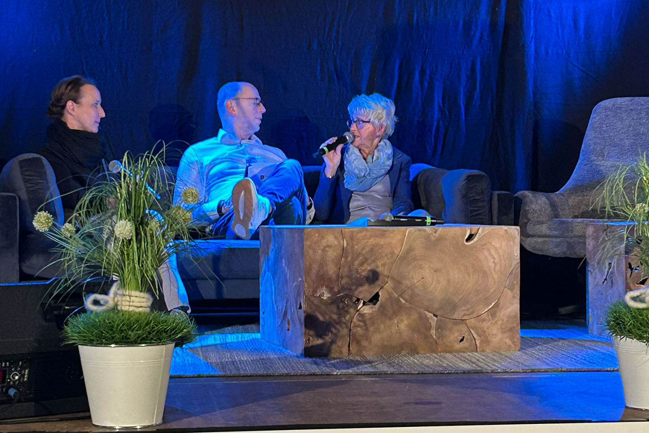 Zwei Frauen und ein Mann auf einer Couch