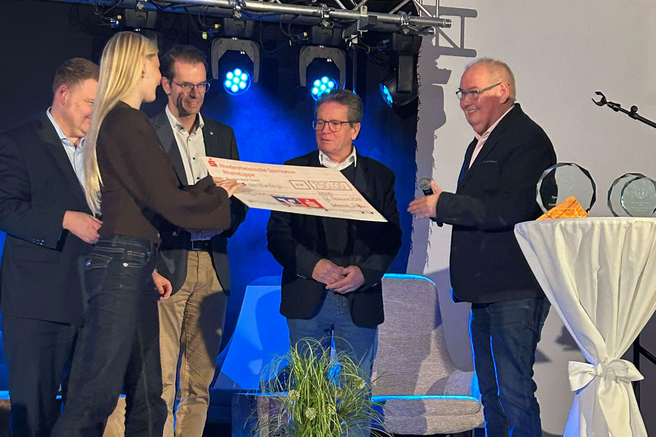 Scheckübergabe an eine junge Frau