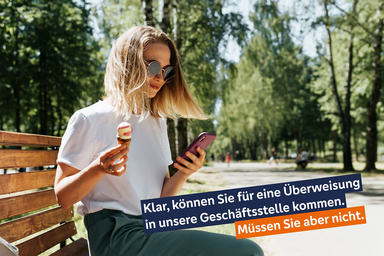Eine junge Frau sitz auf einer Bank und hält in der linken Hand ein Handy. In der rechten Hand hält sie ein Eis.