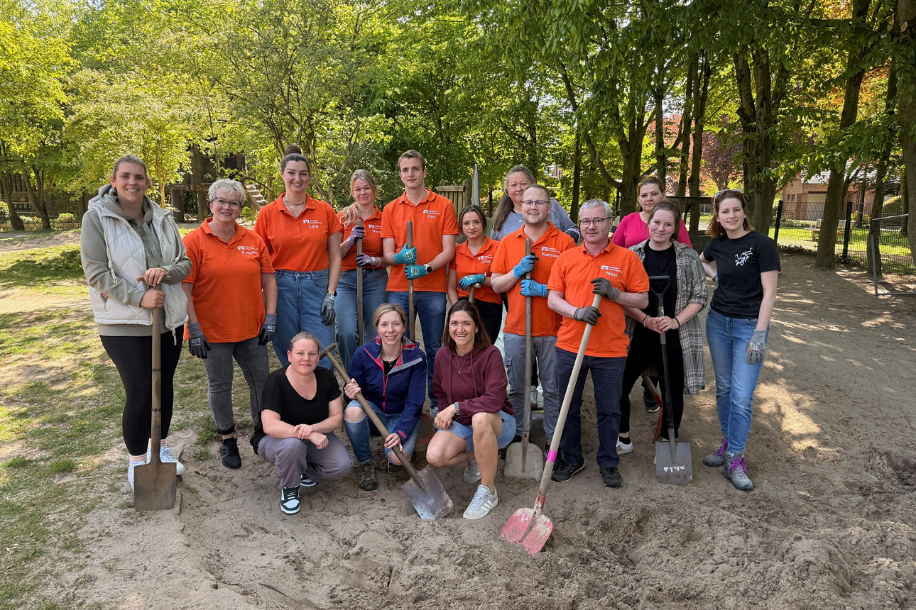 Gruppenbild der Helfer mit 15 Personen im Garten Kindergarten St. Kilian