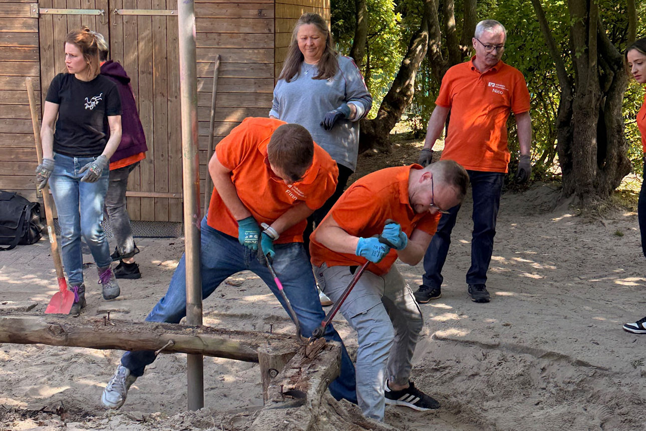 Zwei Männer versuchen mit jeweils einem Stemmeisen einen alten Holzrahmen zu trennen.