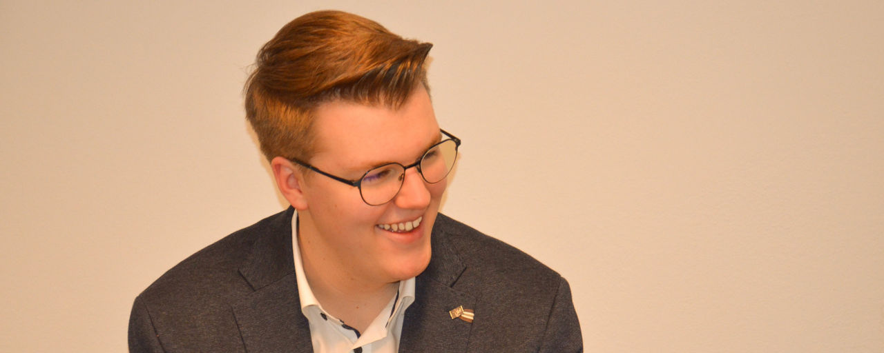 Freundlich lächelnder junger Mann im Anzug