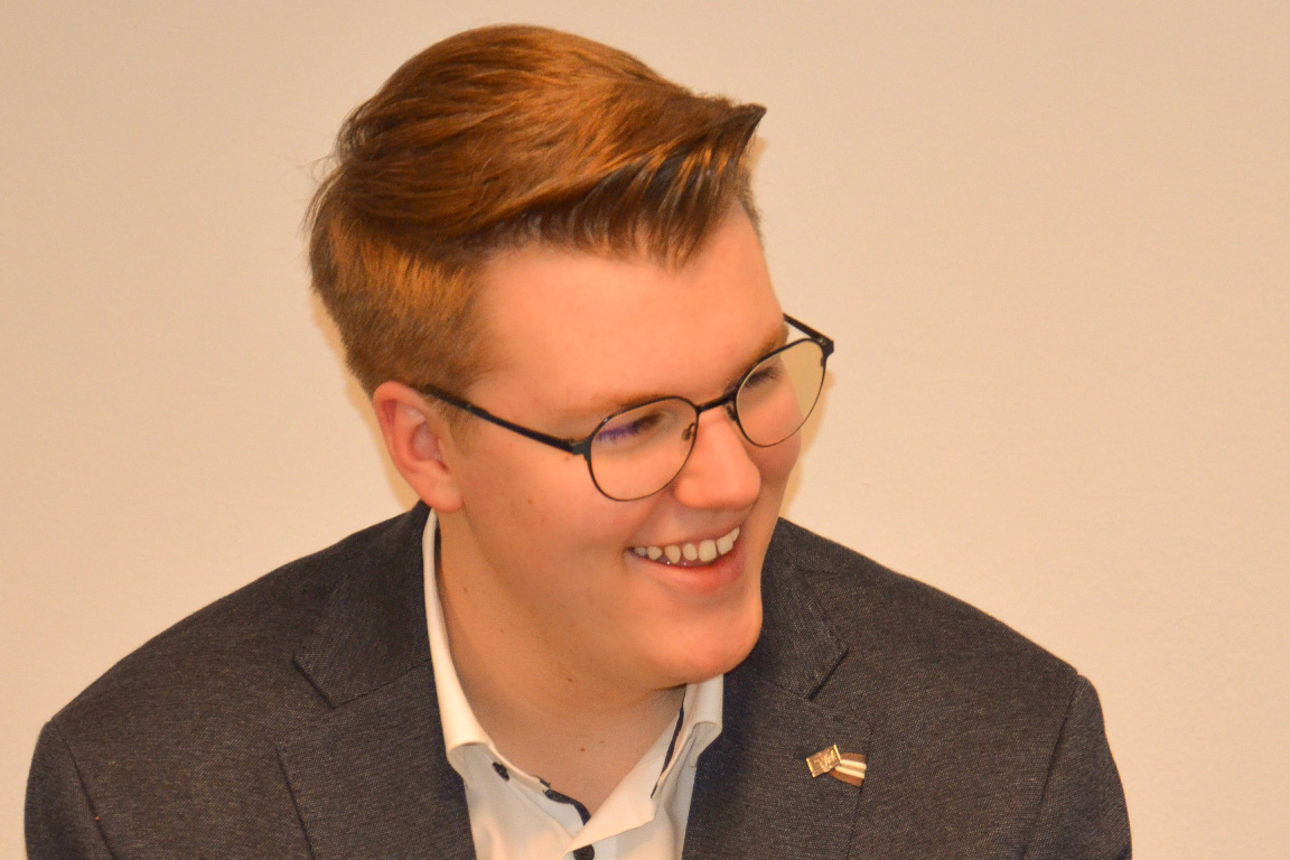 Freundlich lächelnder junger Mann im Anzug