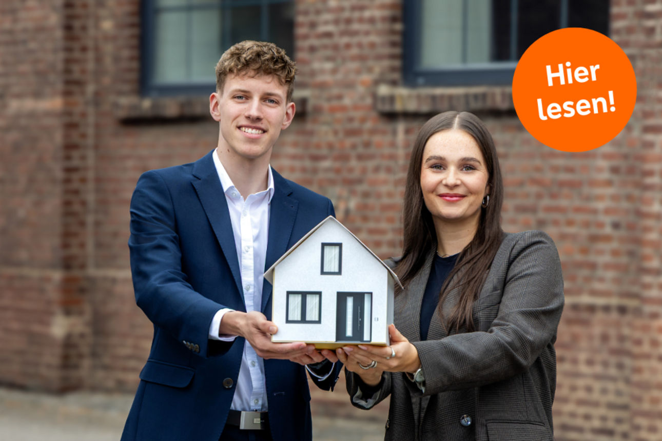 Foto Mann und Frau halten zusammen ein Haus aus Papier - Text: Hier lesen!"