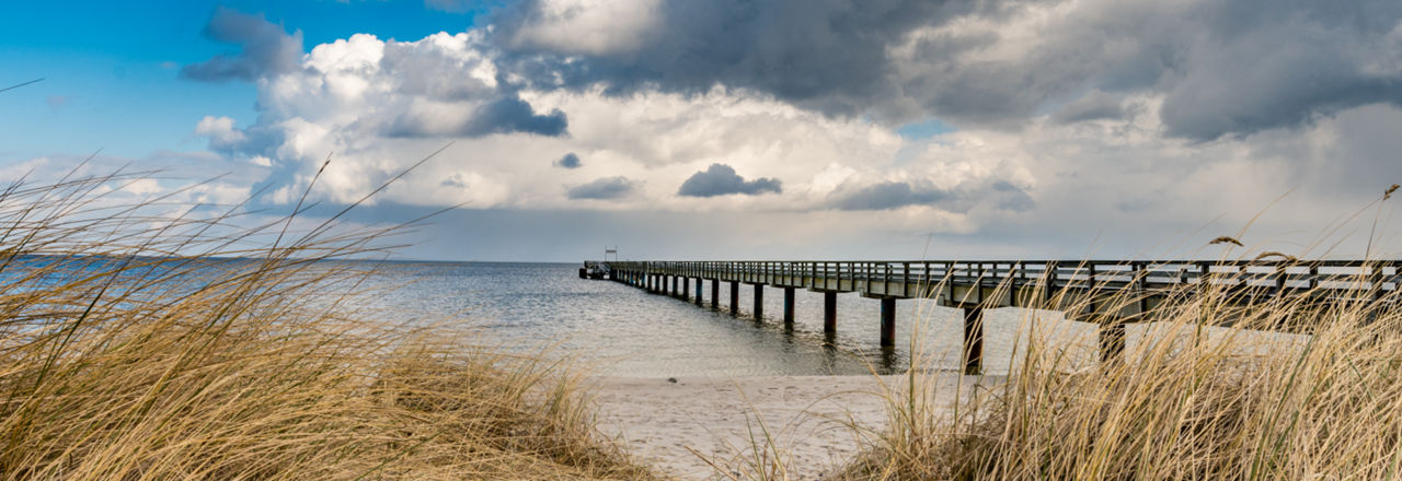 Steg ins Meer im Vordergrund Dünen