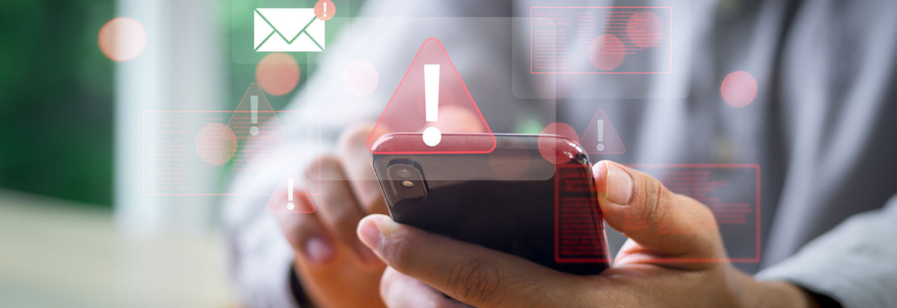 Mann bedient Handy und Warnzeichen werden angezeigt
