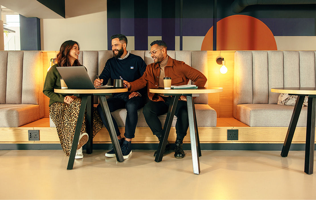 Drei Personen sitzen in einem Coop Workspace