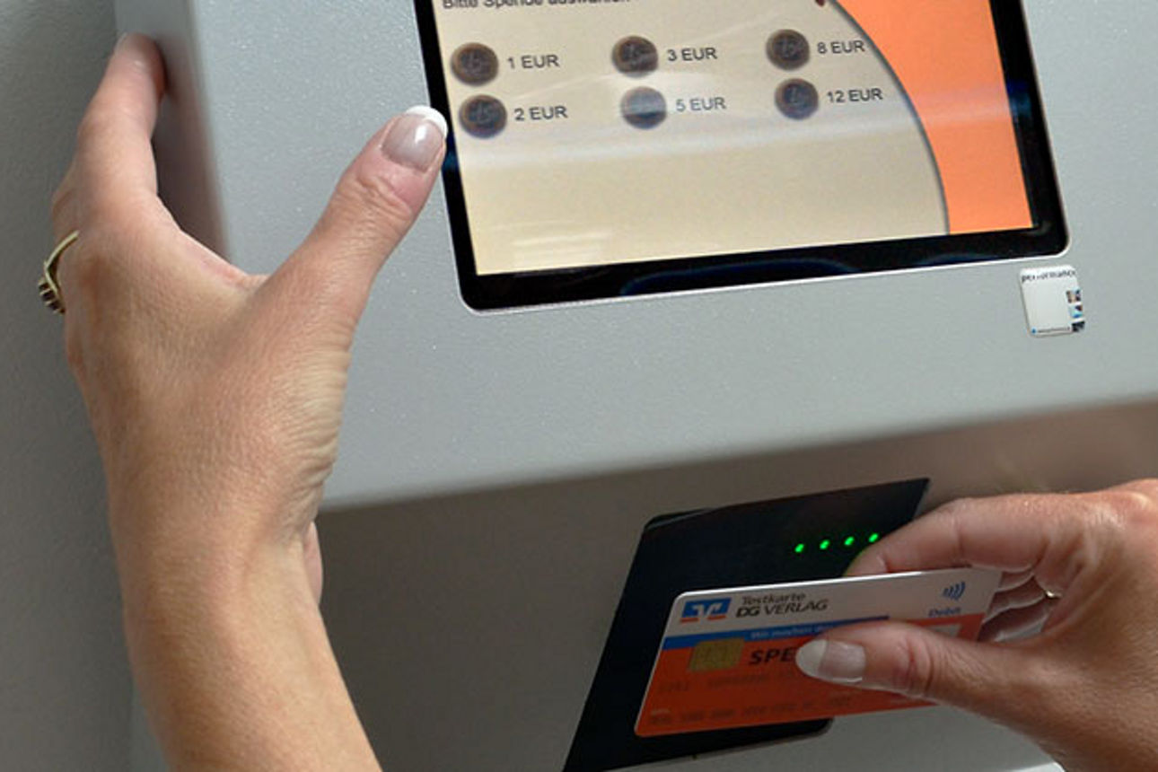 Frau spendet über ein stationäres Spendenterminal