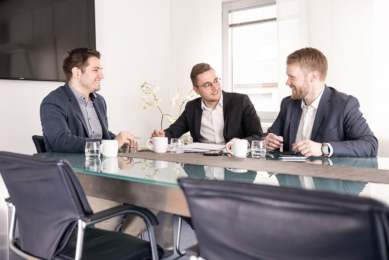 Mitarbeiter sitzen zusammen an einem Tisch und tauschen sich aus