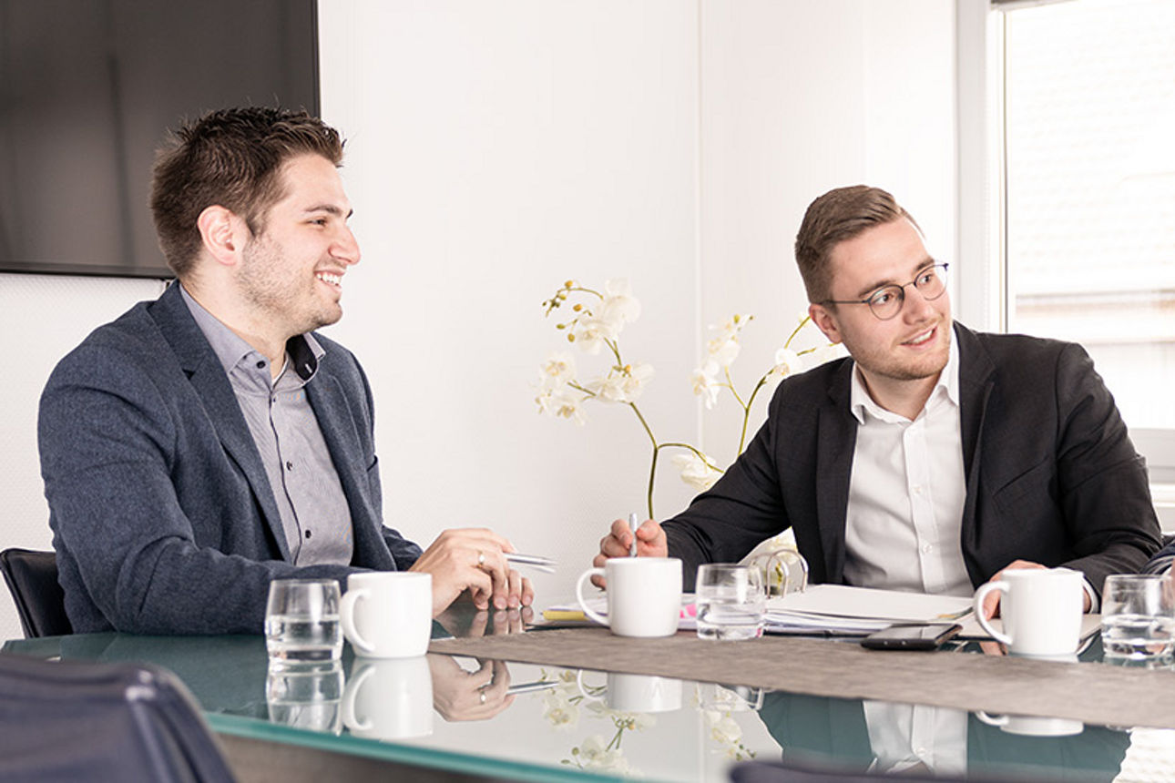 Mitarbeiter sitzen zusammen an einem Tisch und tauschen sich aus