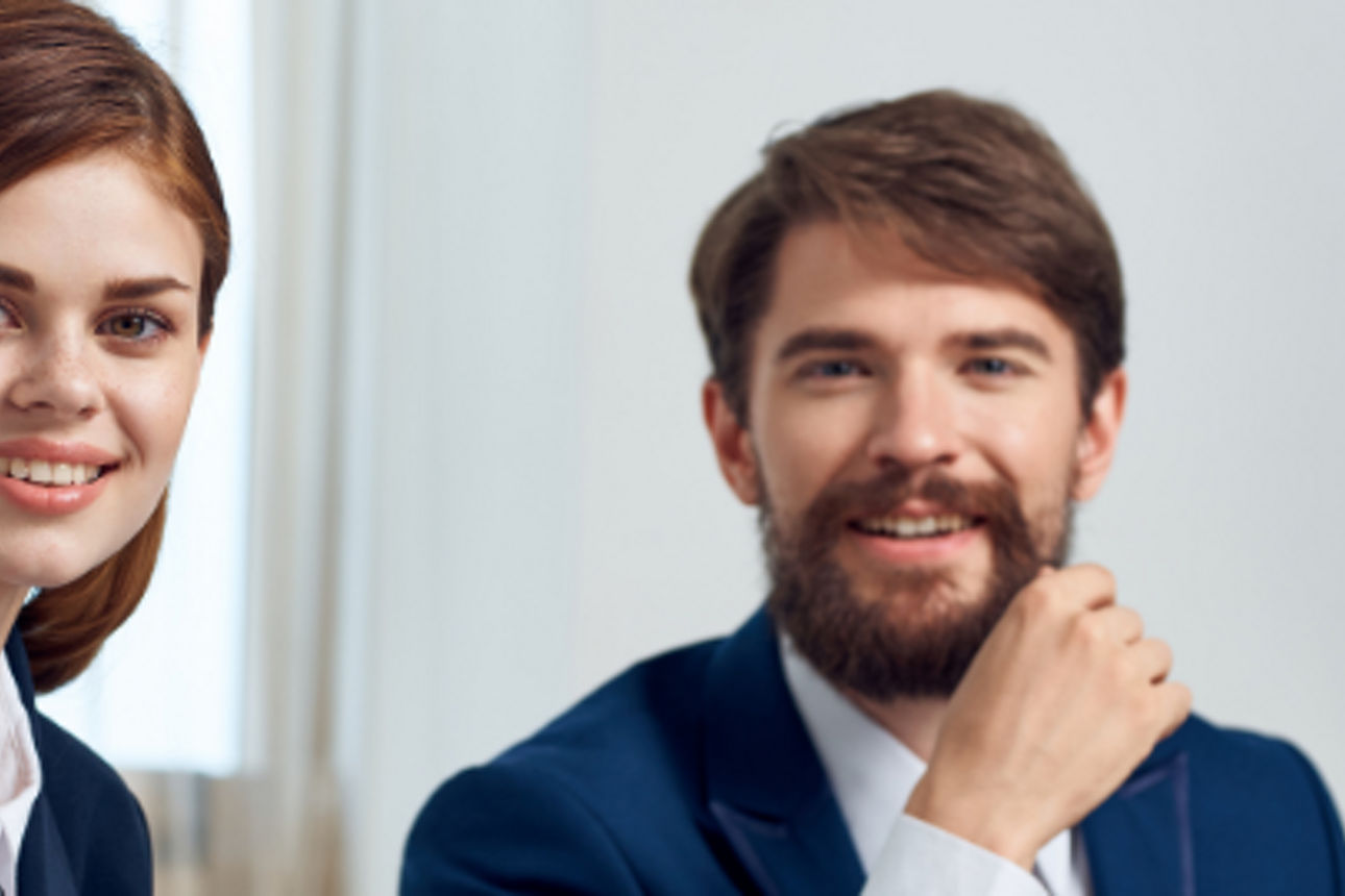 Frau und Herr im Anzug lächeln