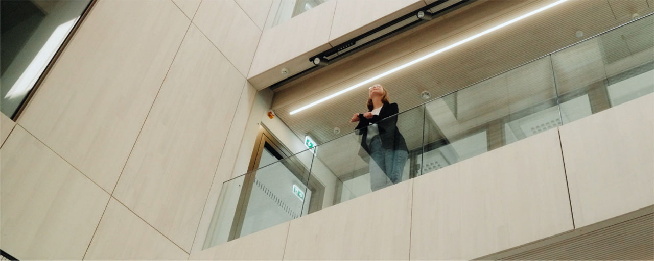 Mitarbeitern steht an Galerie und schaut in die Ferne
