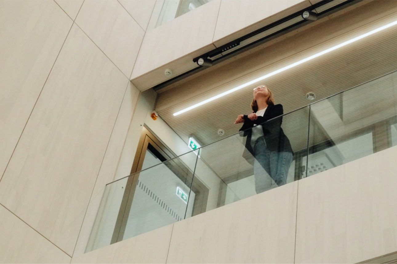 Mitarbeitern steht an Galerie und schaut in die Ferne