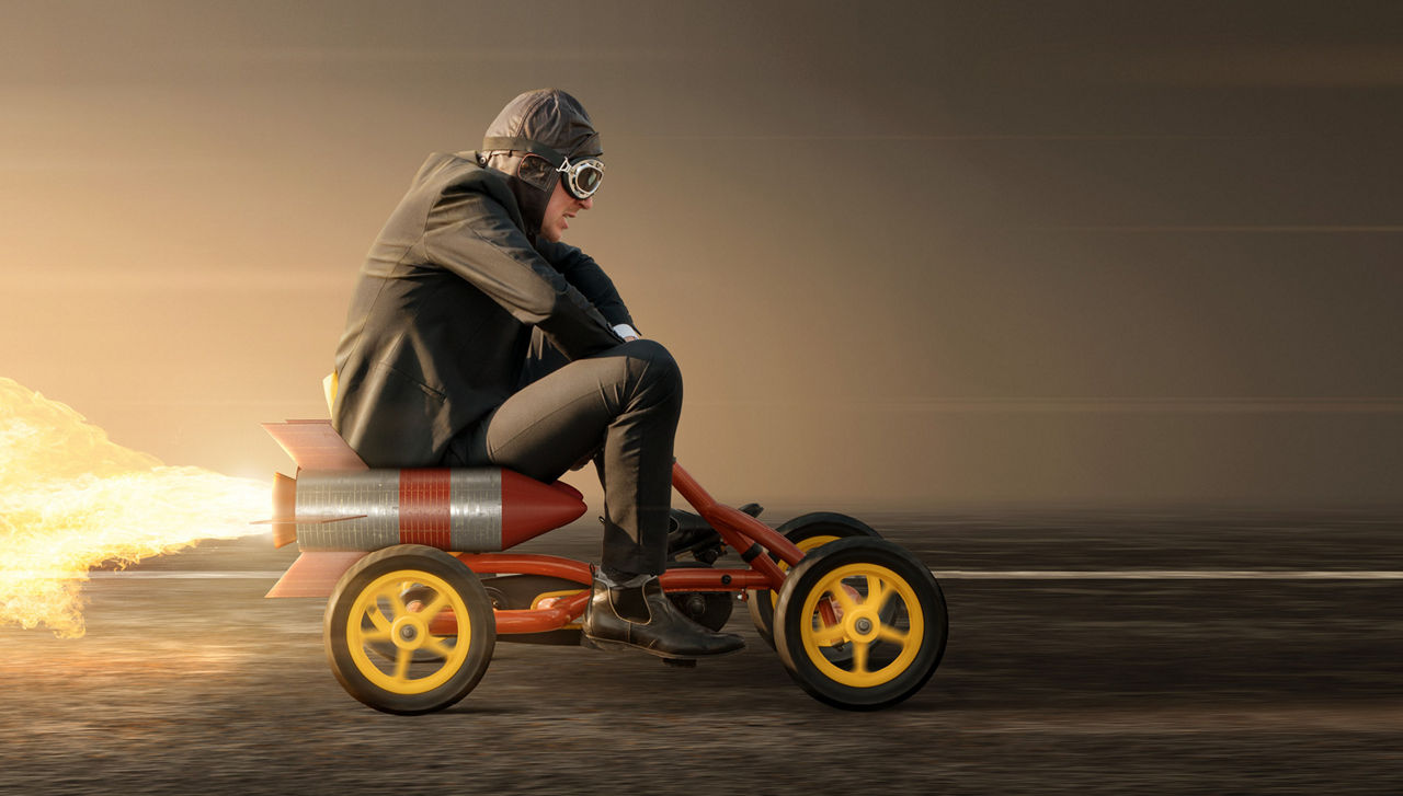ein Mann sitzt auf einem Kettcar mit Raketenantrieb
