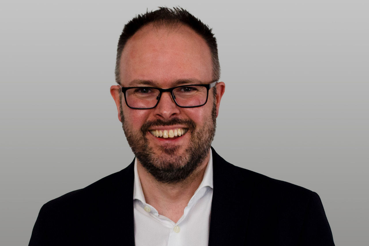 Bereichsleiter Baufinanzierung Andre Stepahn vor grauen Hintergrund