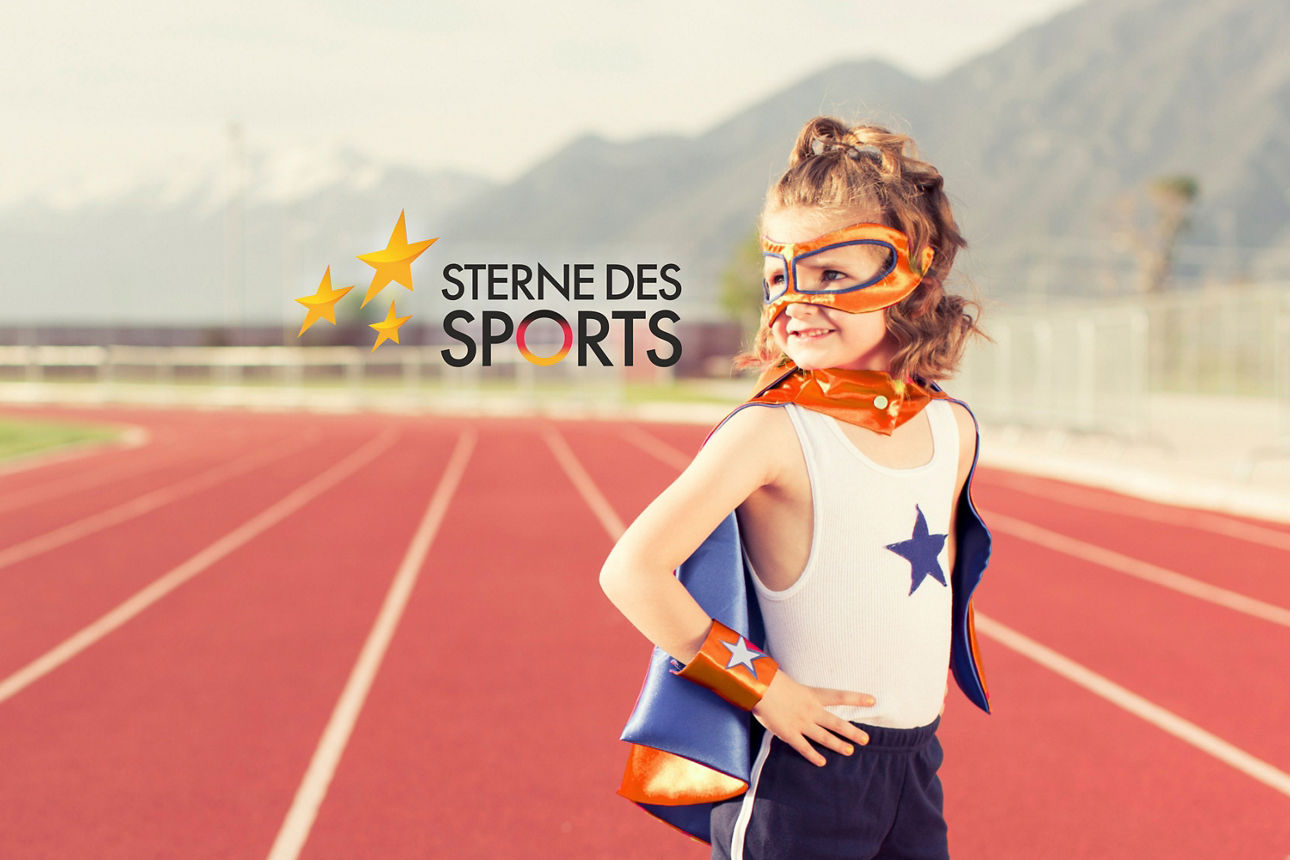 Ein Kind in Superheldenkostümen steht auf einer Laufstrecke