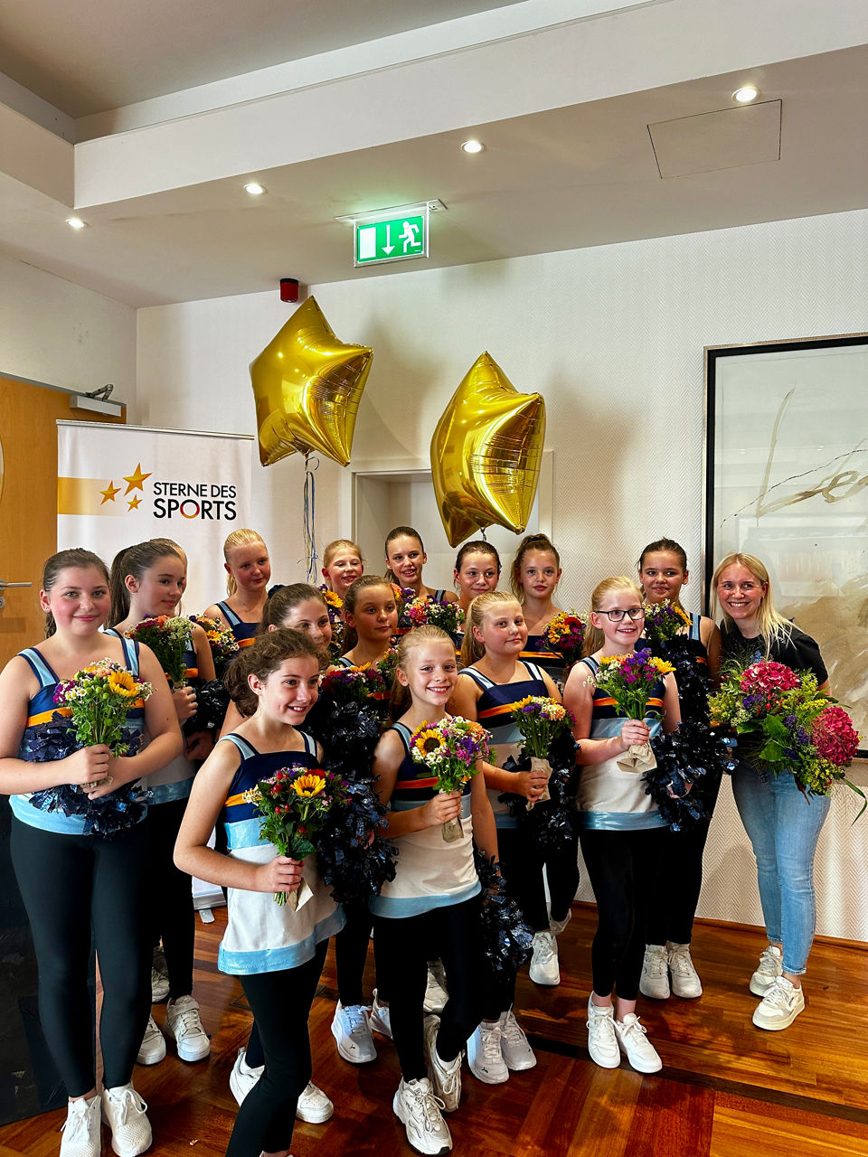 Sterne des Sports Team der Mini Dancers nach ihrem Auftritt mit Blumen in der Hand