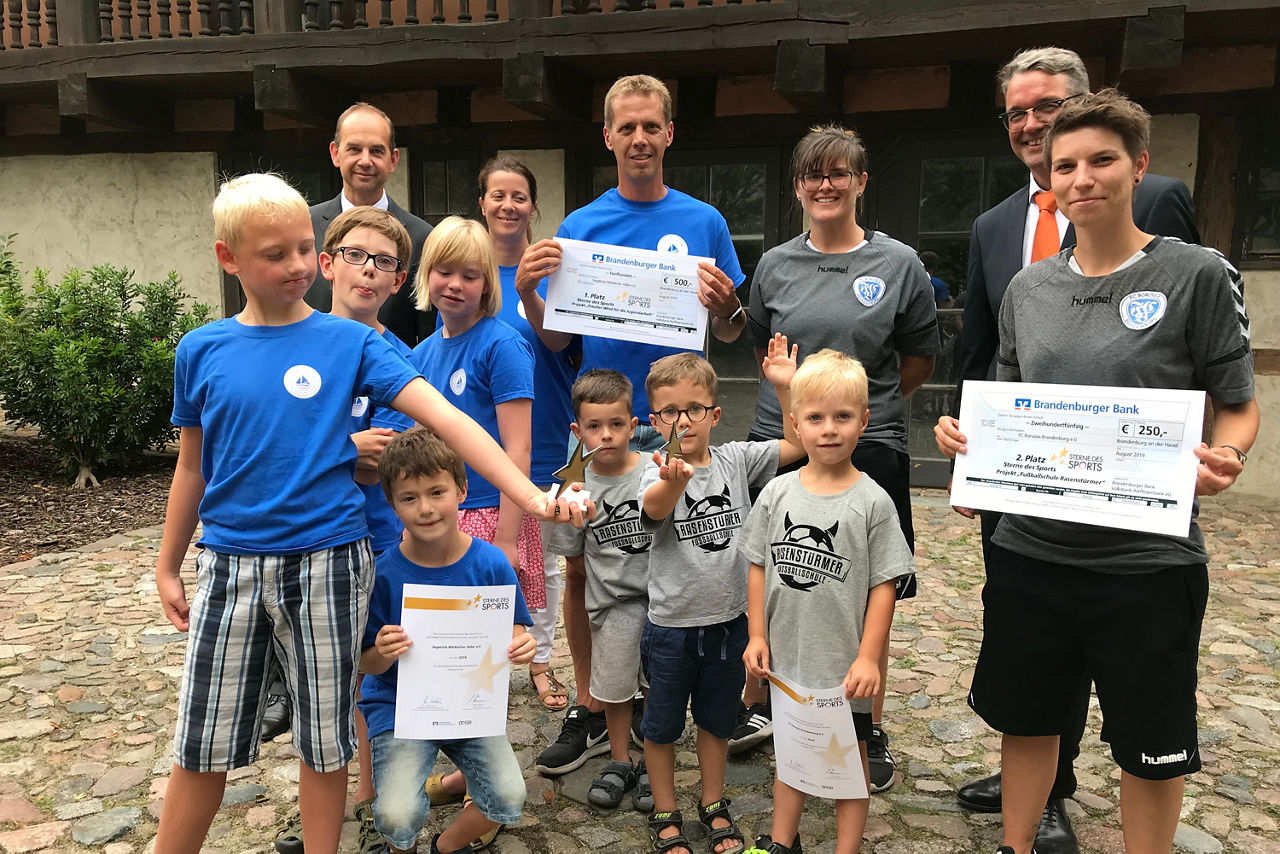 Fußballkinder und Trainer halten Stern und Urkunde in den Händen