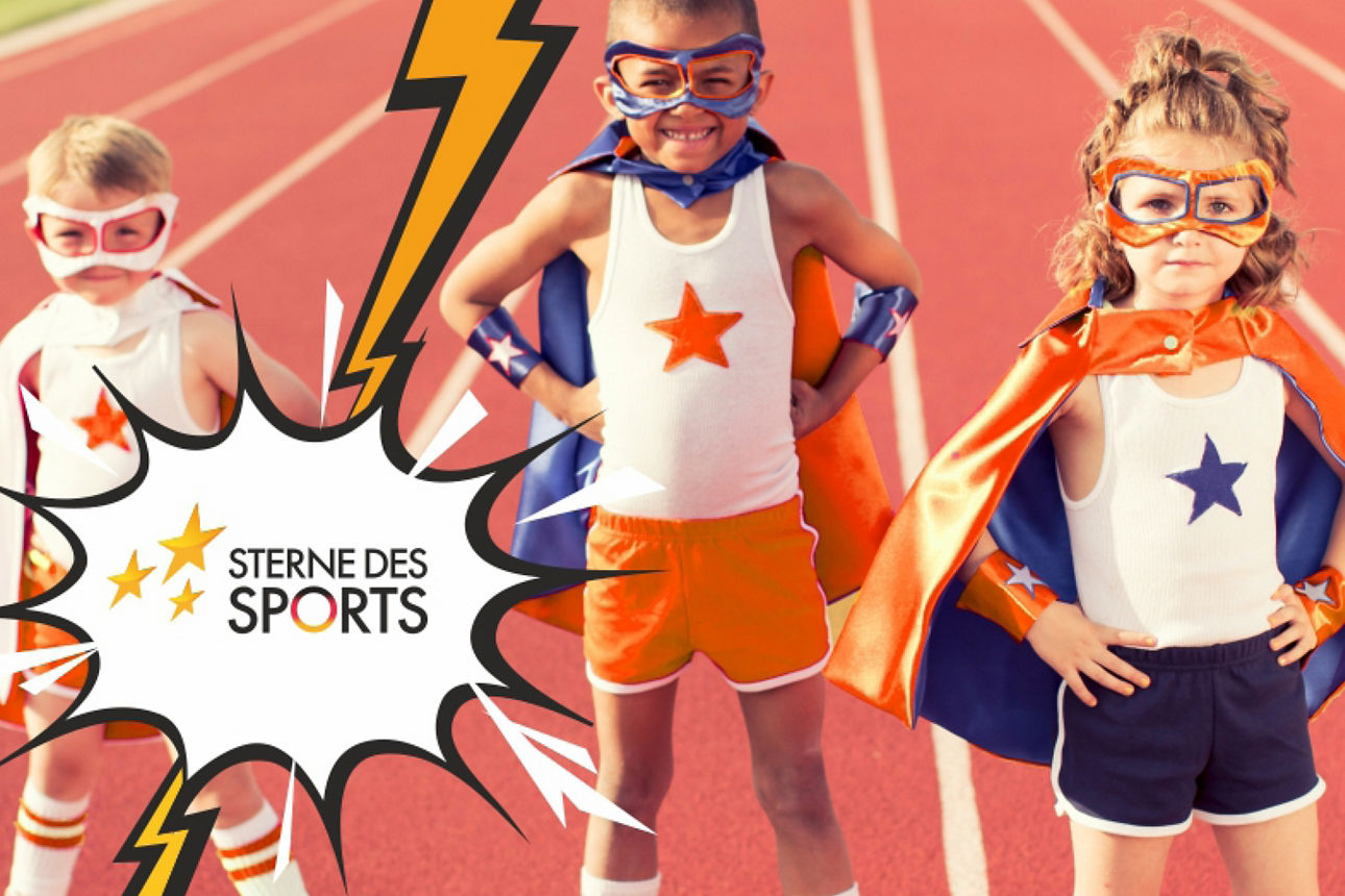 3 Kinder im Sterne-Superman-Outfit auf einer Aschenbahn