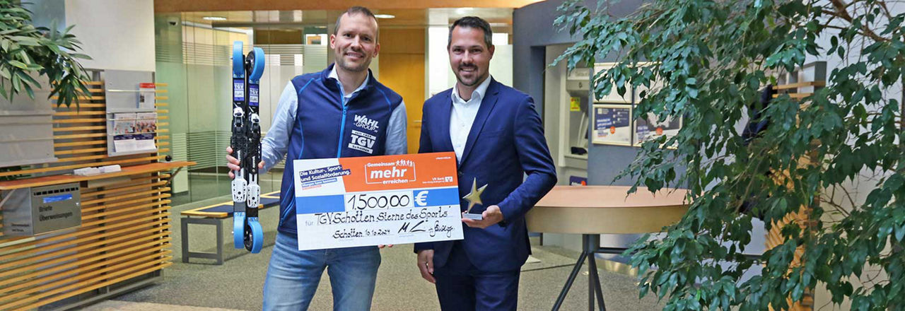 Das Bild zeigt die Auszeichnung "Sterne des Sports" für den TGV Schotten. Ein Vertreter der Bank und einer des Vereins halten den Spendenscheck.