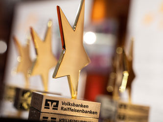 Auf dem Bild sind fünf Pokale in Form eines goldenen Sterns zu sehen.