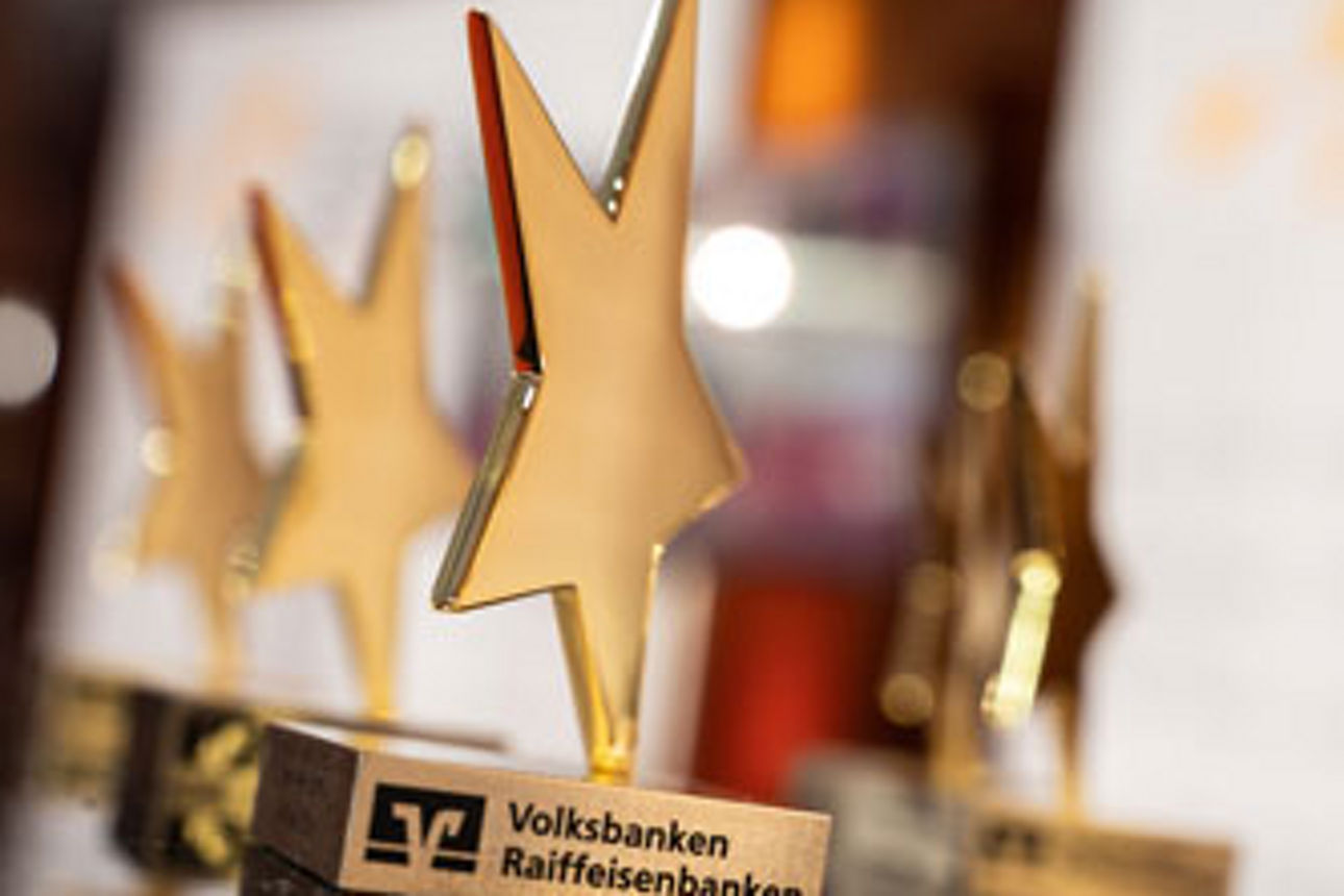 Auf dem Bild sind fünf Pokale in Form eines goldenen Sterns zu sehen.