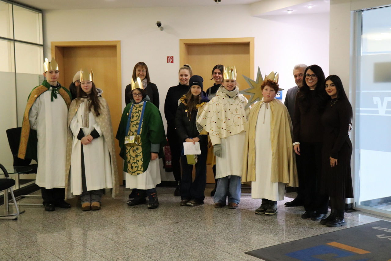 Kinder Sternsinger Bischofsheim stehen in der Bank mit unseren Mitarbeitern