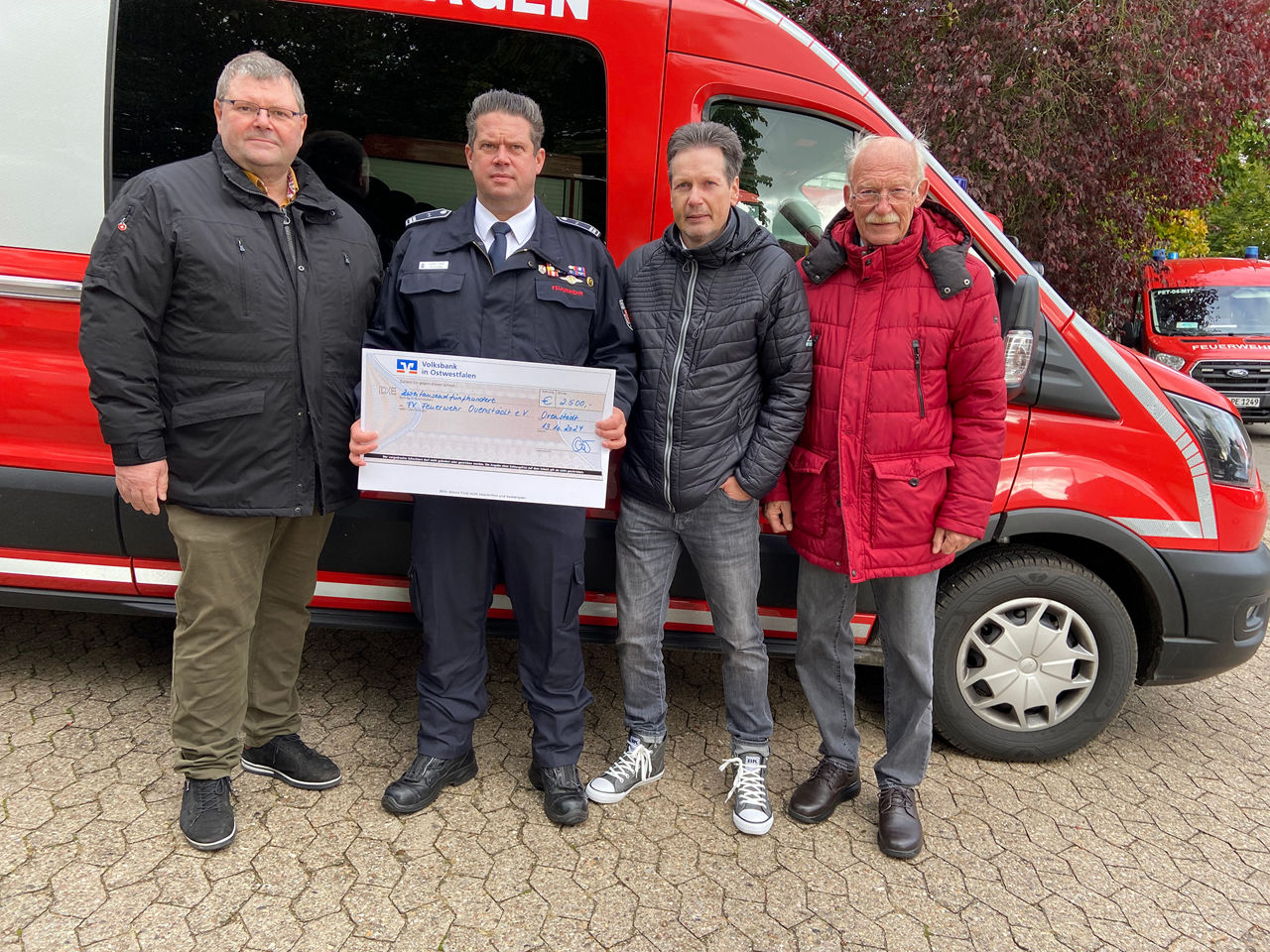 Drei Vertreter der VB Stiftung - Mindener Land und ein Vertreter der Feuerwehr bei der Übergabe des Spendenschecks.