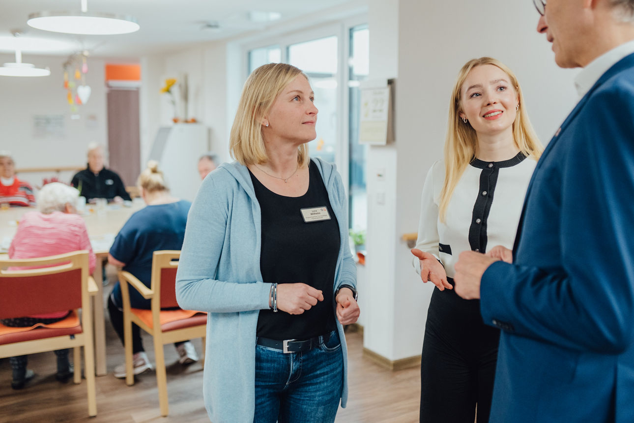 Drei Personen in einem Gespräch in einer Caritas-Einrichtung