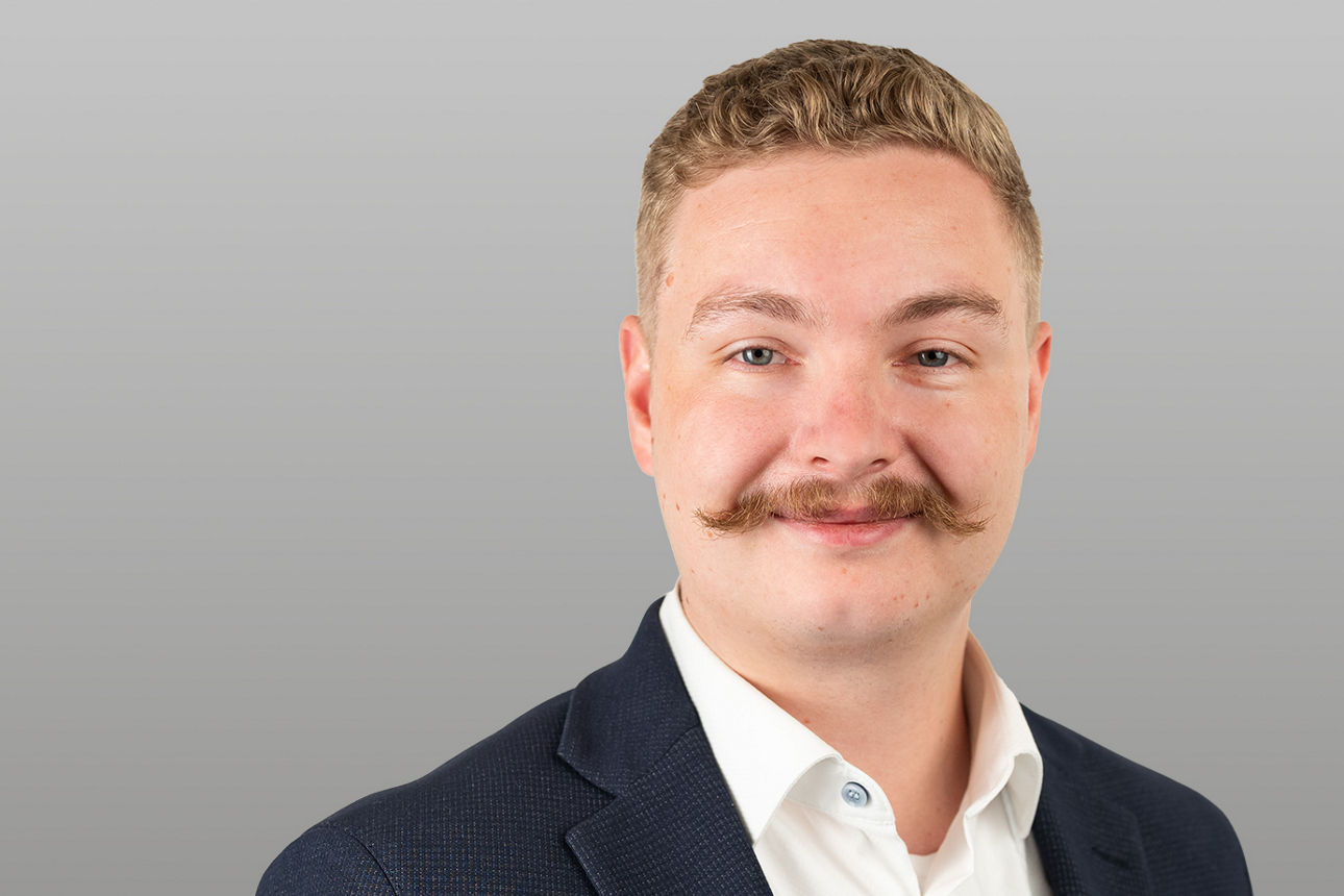 Privatkundenberater Philipp Stolba vor grauen Hintergrund