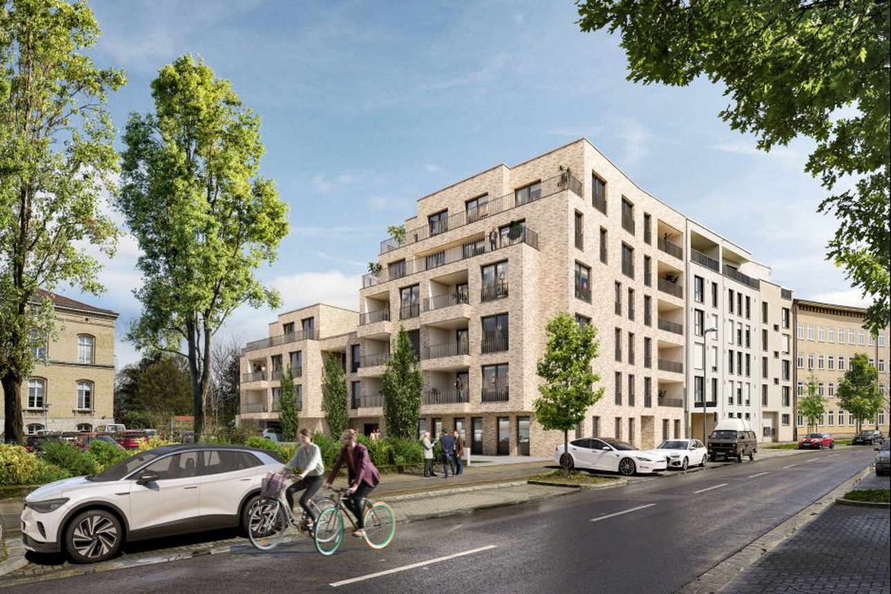 Modernes, mehrstöckiges Wohnhaus aus Backstein an einer Straße mit Bäumen, parkenden Autos und zwei Radfahrern.