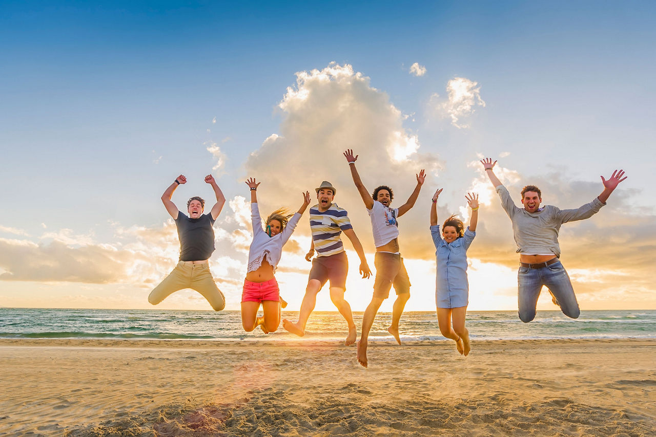Junge Leute springend am Strand