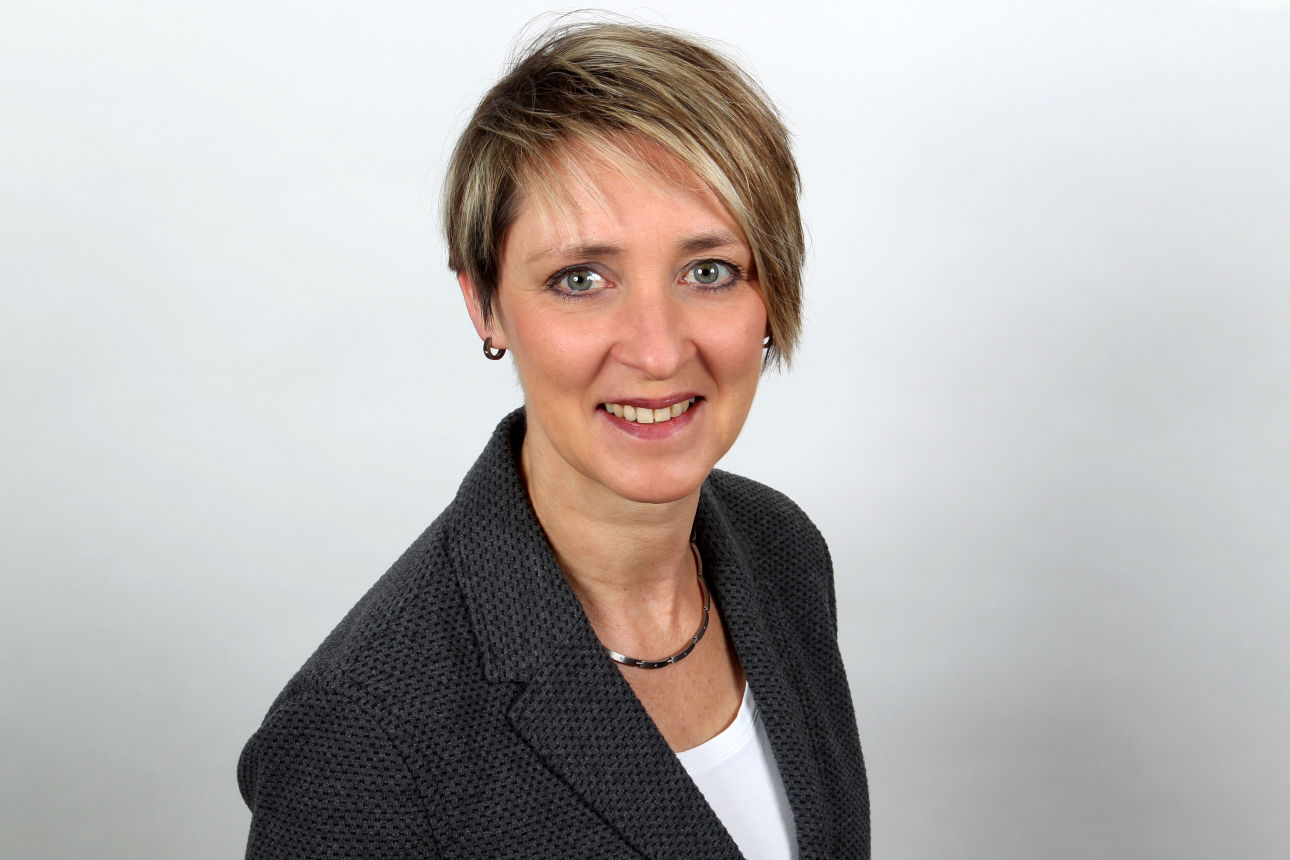 Eine lächelnde Frau schaut in die Kamera.