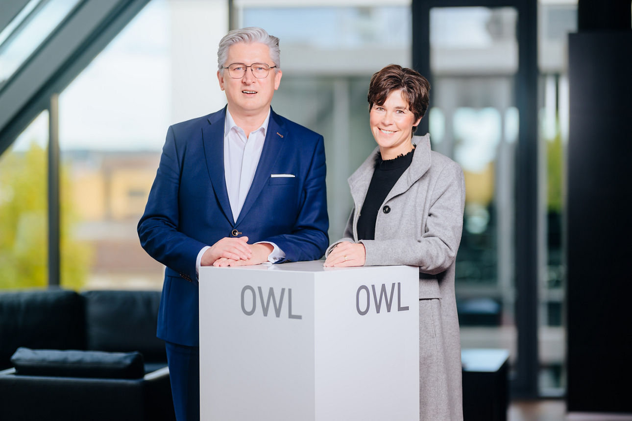 Die Geschäftsführerin der Stiftung Studienfonds OWL und der Vorstandsvorsitzende der VerbundVolksbank OWL  stehen an einem Pult.