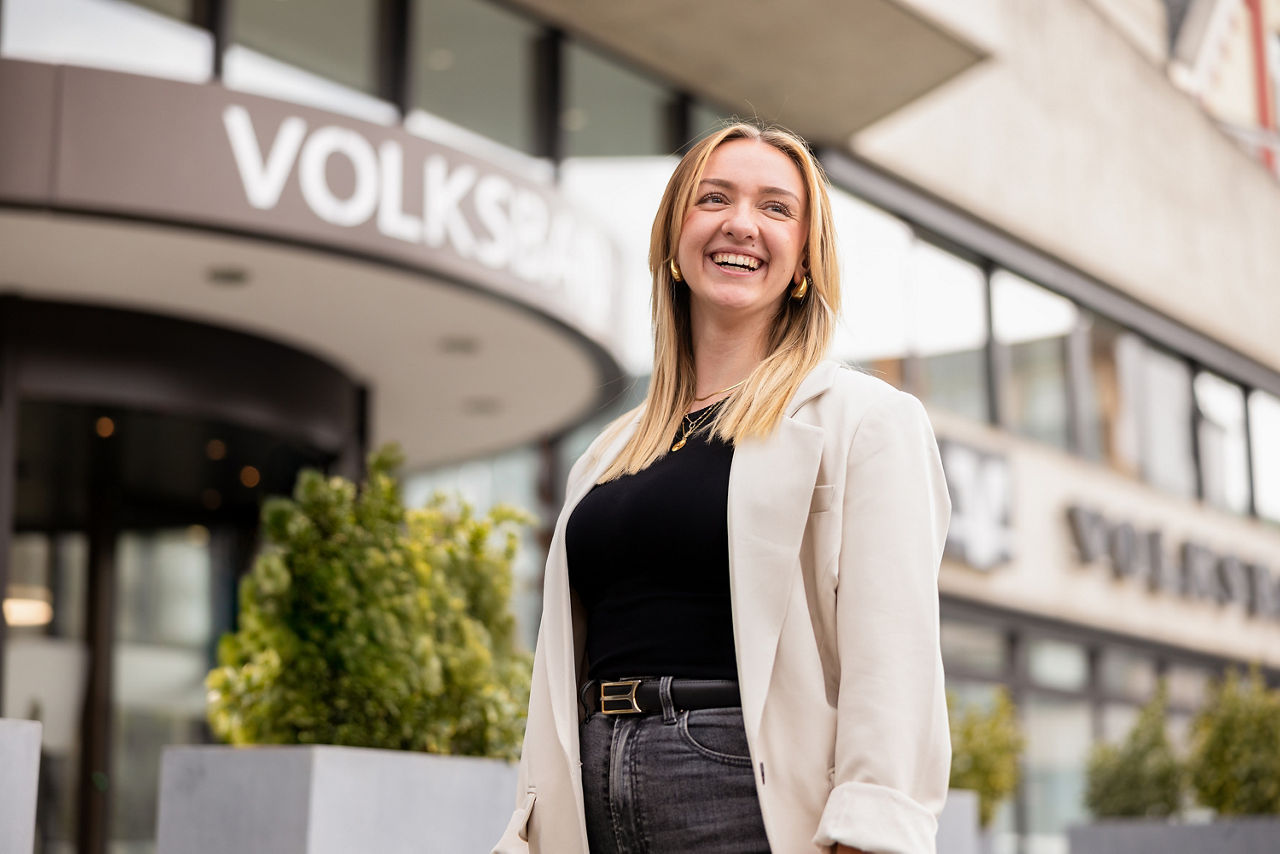 Junge Frau vor einem Volksbank-Gebäude