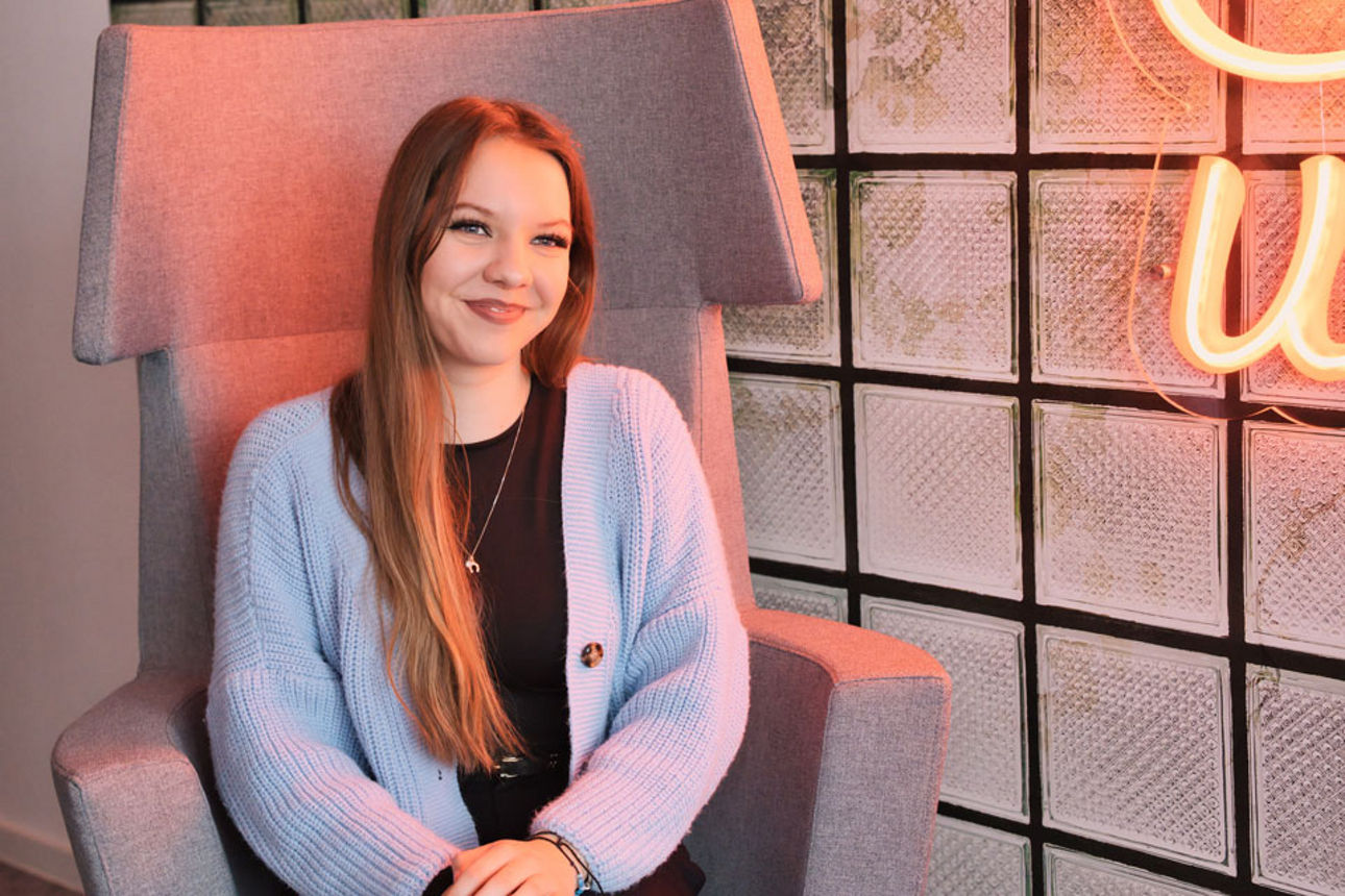 Junge Frau sitzt im Stuhl und lacht