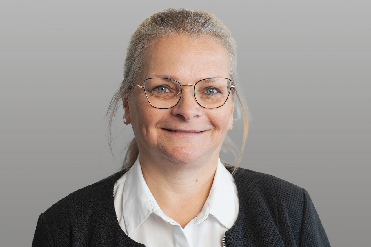 Servicemitarbeiterin Ines Stumpe vor grauen Hintergrund