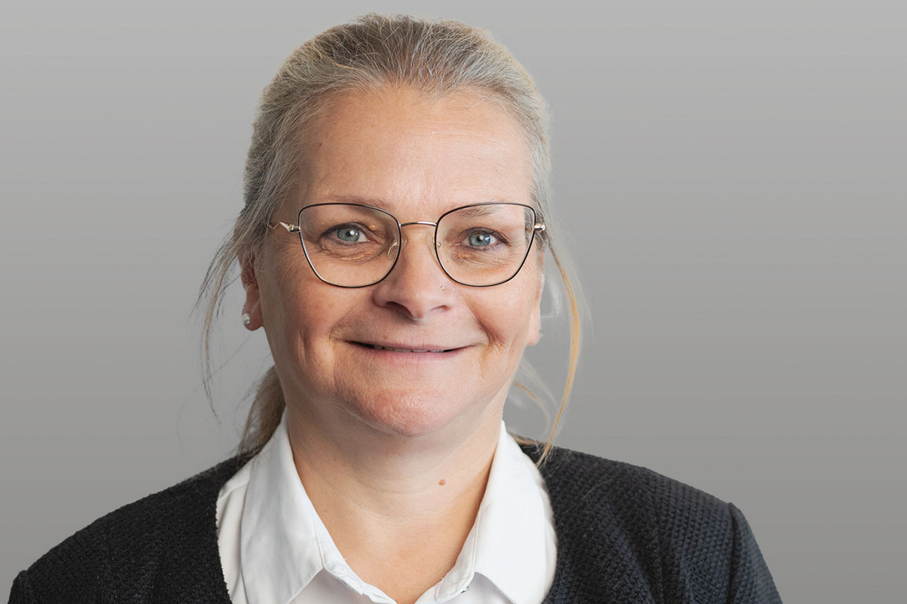 Servicemitarbeiterin Ines Stumpe vor grauen Hintergrund