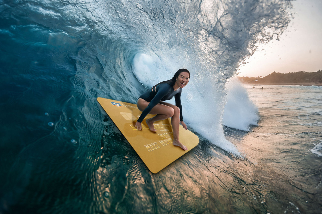 Surferin auf der goldenen Kreditkarte.