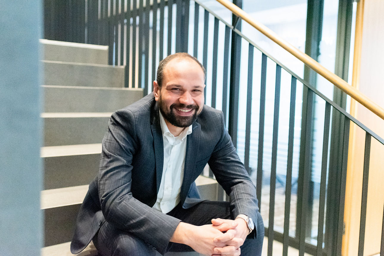 Junger Mann sitzt auf Treppenstufen.