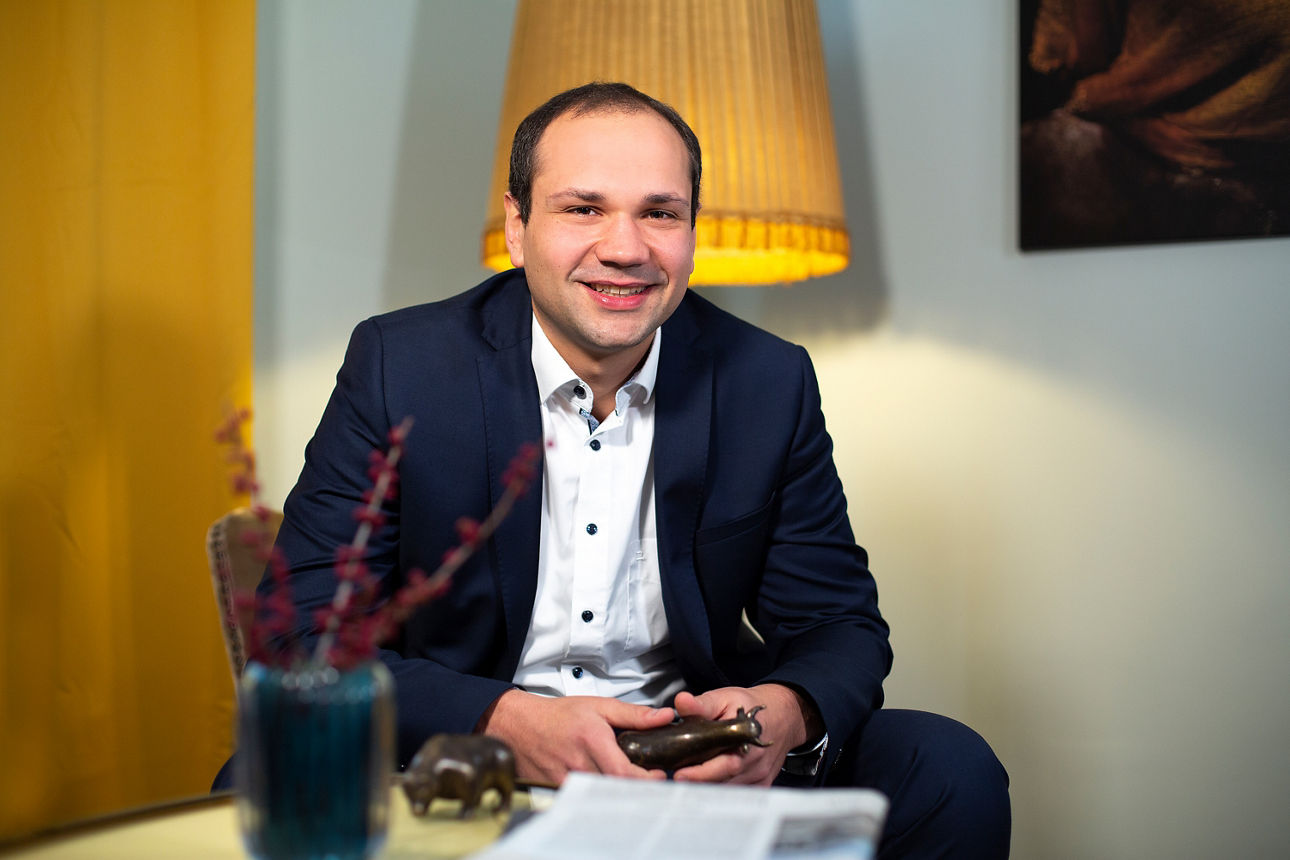 Portrait Sven Olbrich sitzend vor Lampe