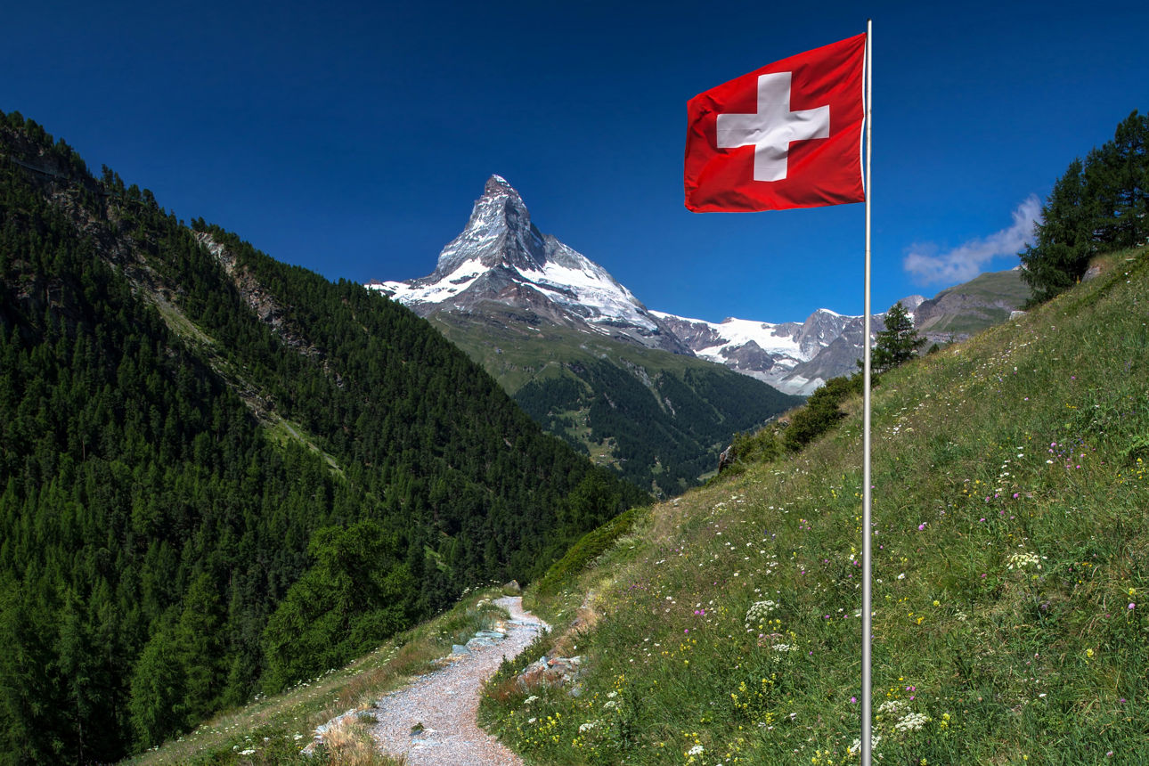 Die schweizer Flagge mit dem Matterhorn im Hintergrund