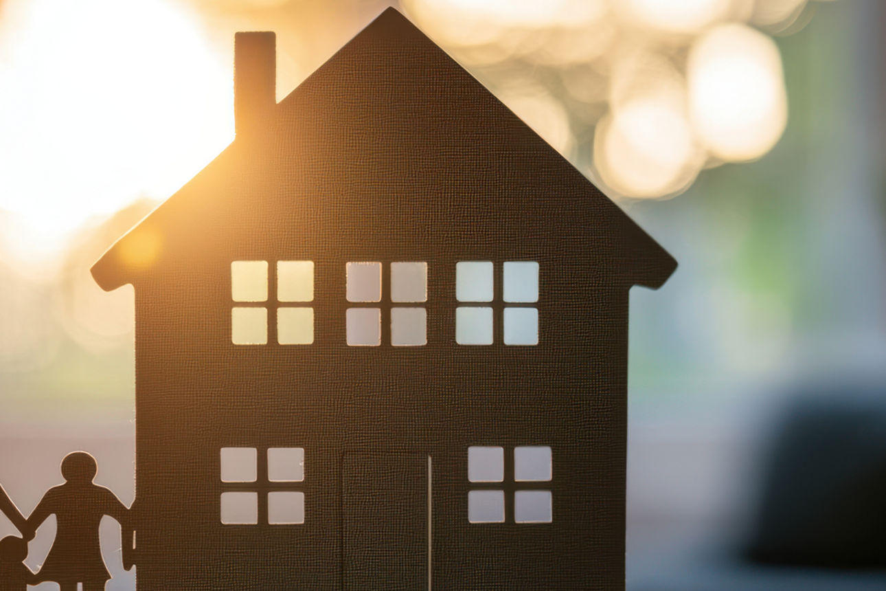 Ein kleines Modellhaus, mit einer Modellfamilie auf der linken Seite.