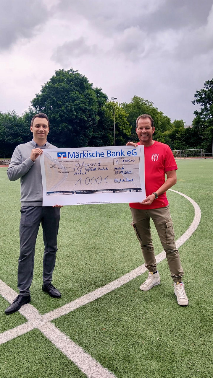 v.l.n.r.: Pascale Osthoff, Michael Lippmann auf dem Fußballfeld bei der Übergabe des Zuwendungsscheck