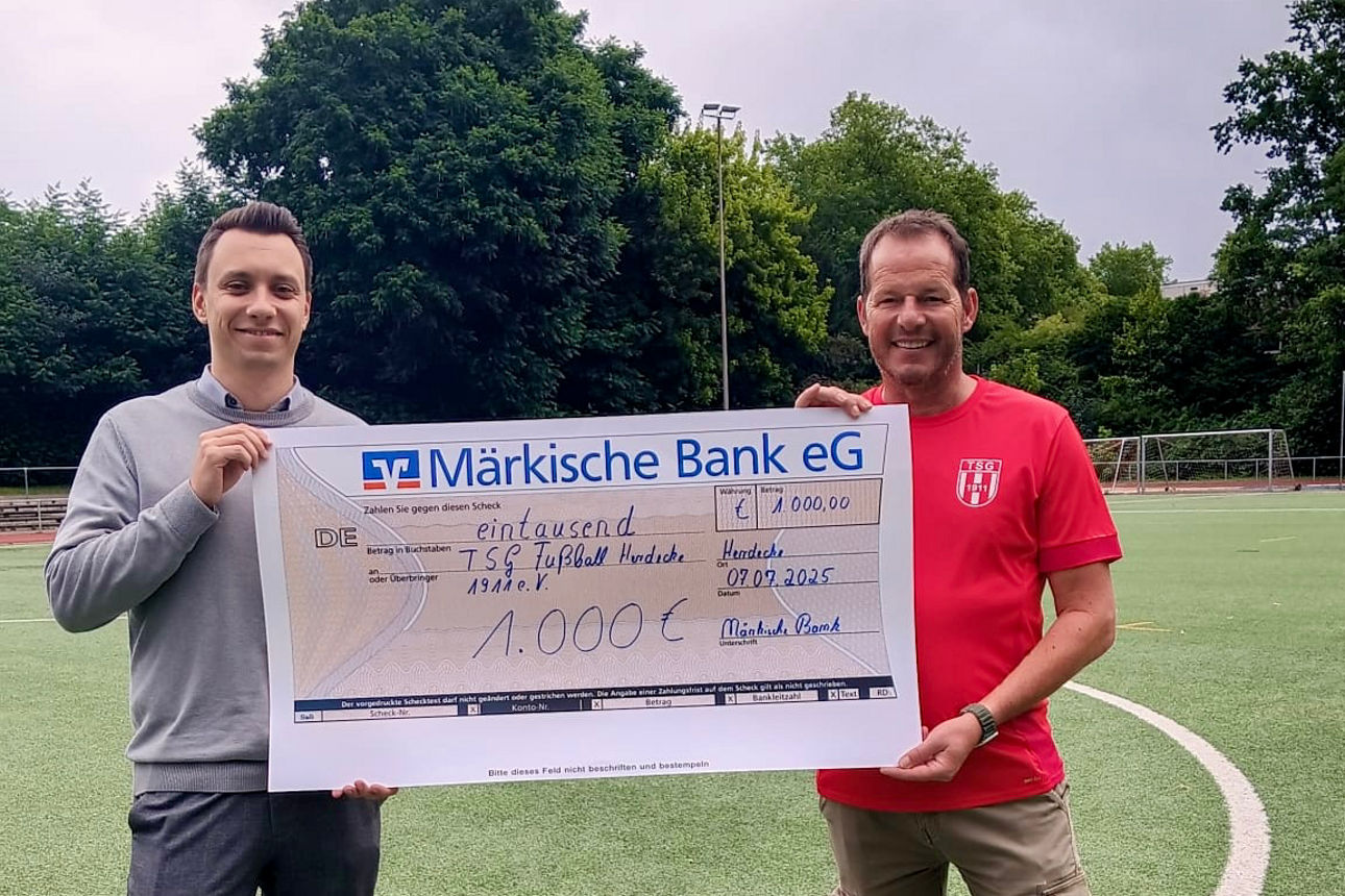 v.l.n.r.: Pascale Osthoff, Michael Lippmann auf dem Fußballfeld bei der Übergabe des Zuwendungsscheck