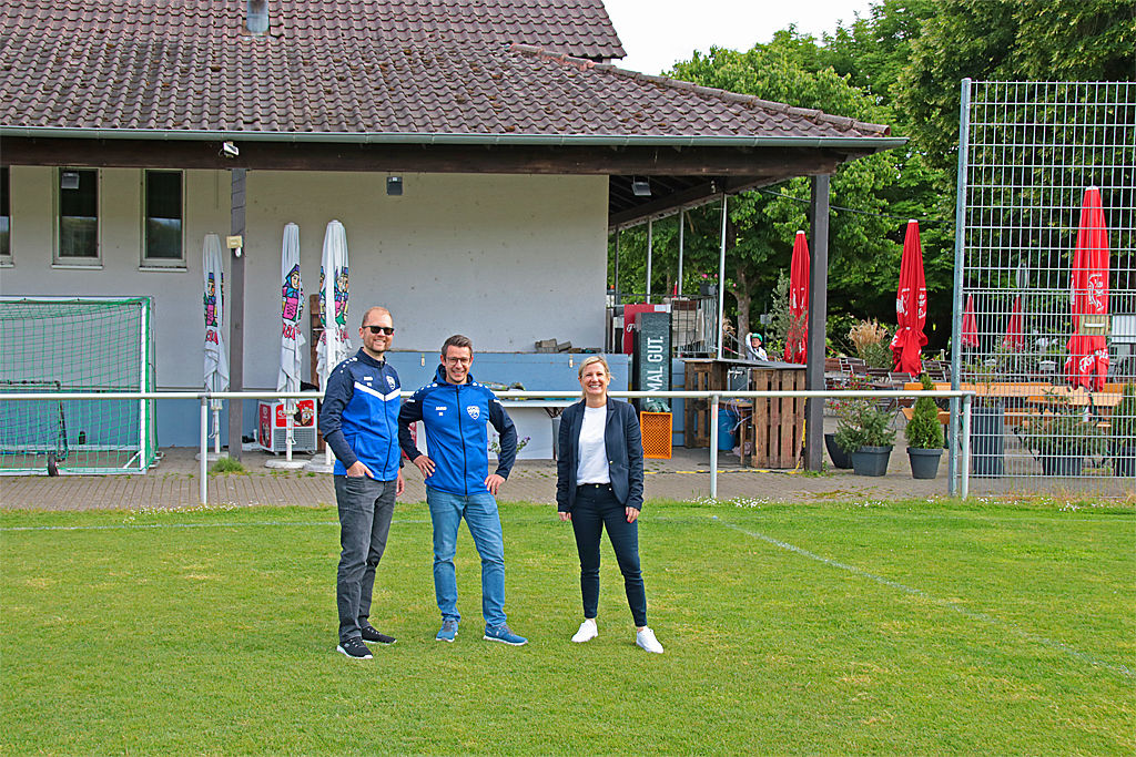 Vereinsmitglieder und Beraterin der VR-Bank auf dem Rasenplatz