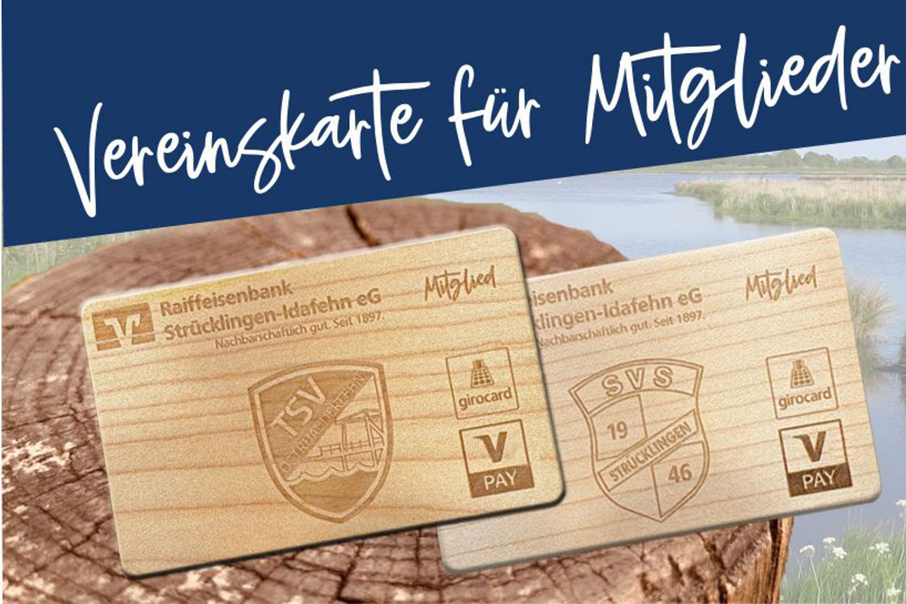 Im Hintergrund Wollgras und im Vordergrund ein Holzstamm auf dem zwei ec-Holzkarten stehen