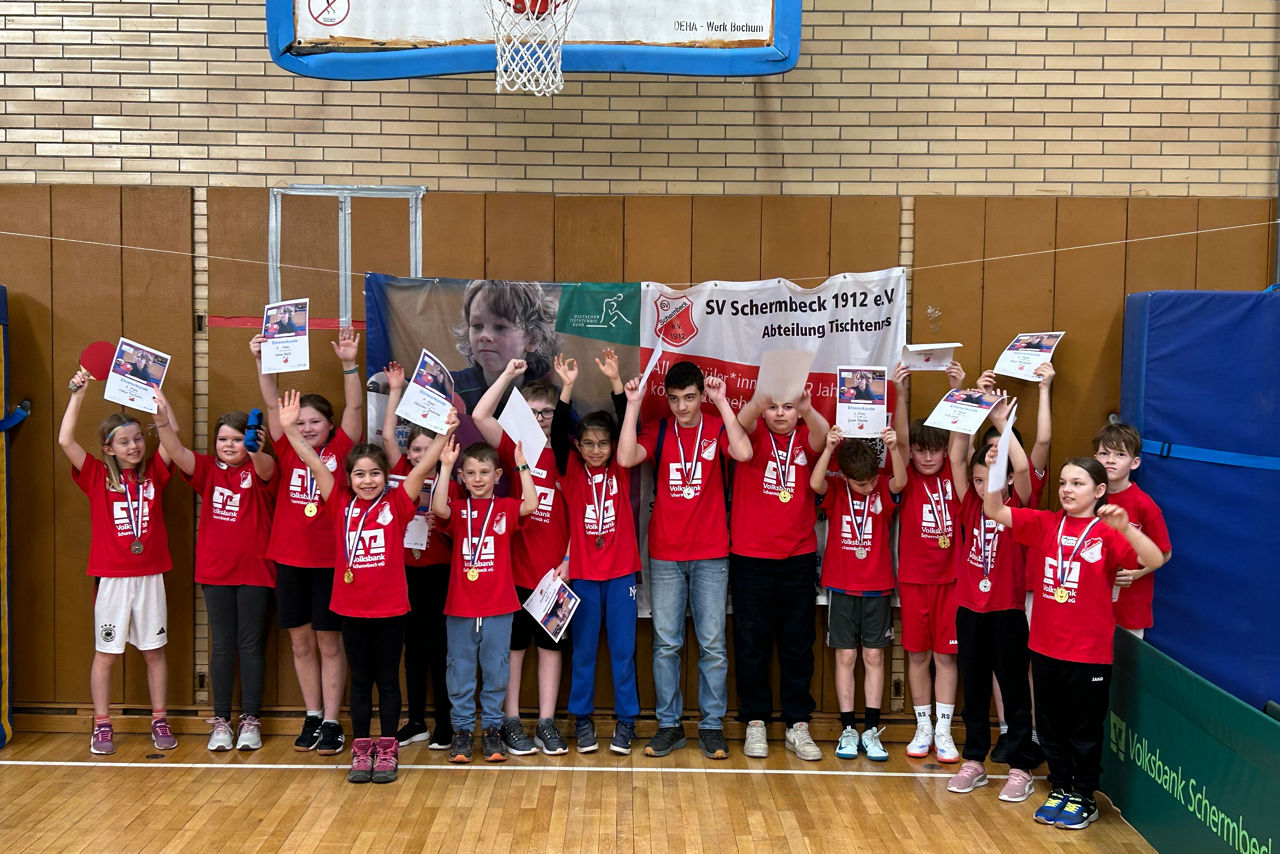 Gruppenbild der Teilnehmer mit Medaillen und Urkunden.