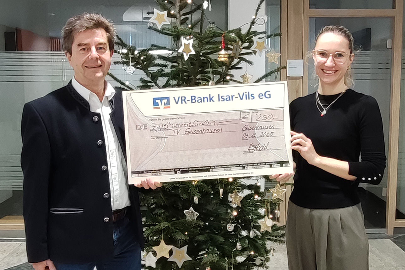 Eine Frau und ein Mann lächeln in die Kamera. Sie halten einen Riesenspendenscheck in der Hand.