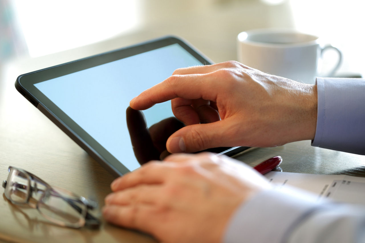Eine Person bedient ein Tablet mit dem Finger